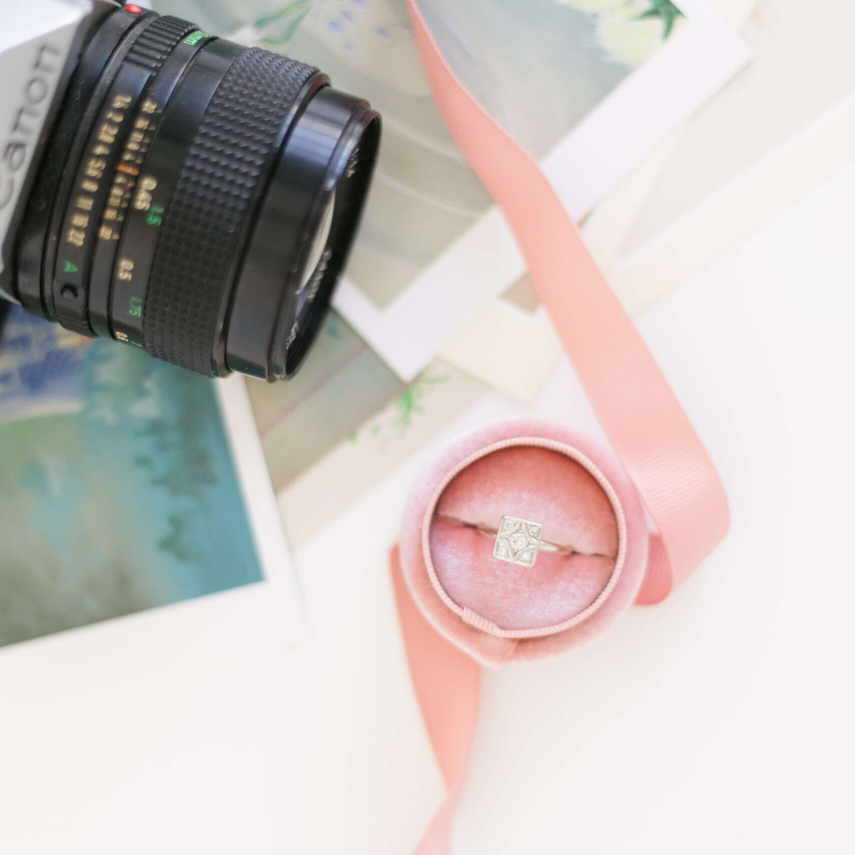 Film Camera and Engagement Ring atop images and a ribbon Veronica Sparrow Kentucky Wedding Photographer